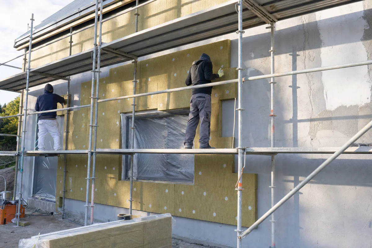 Artisan soufflant de la ouate de cellulose dans les combles perdus d’une maison à Laval