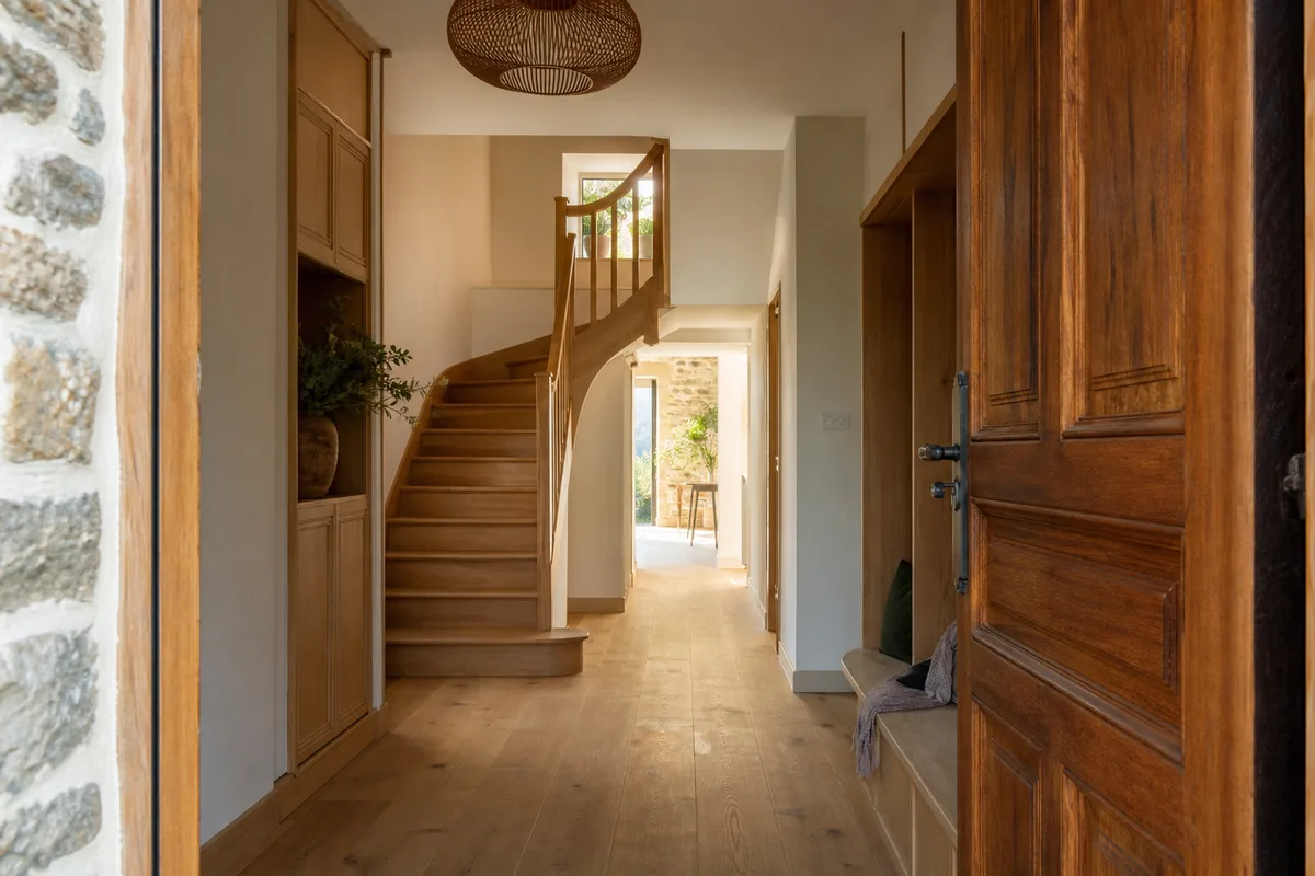 Porte d’entrée bois et escalier sur mesure dans une maison rénovée de la Mayenne